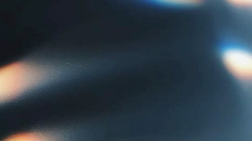 Soft abstract lights against a dark blue surface